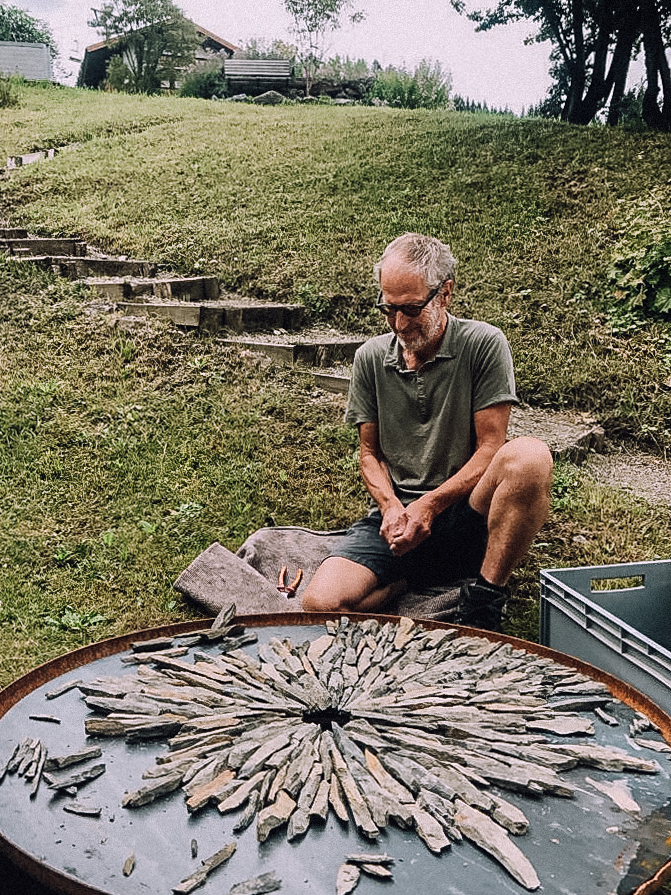 Mann im Naturhotelgarten Kunst in kupferfarbener Schale mit Steinen