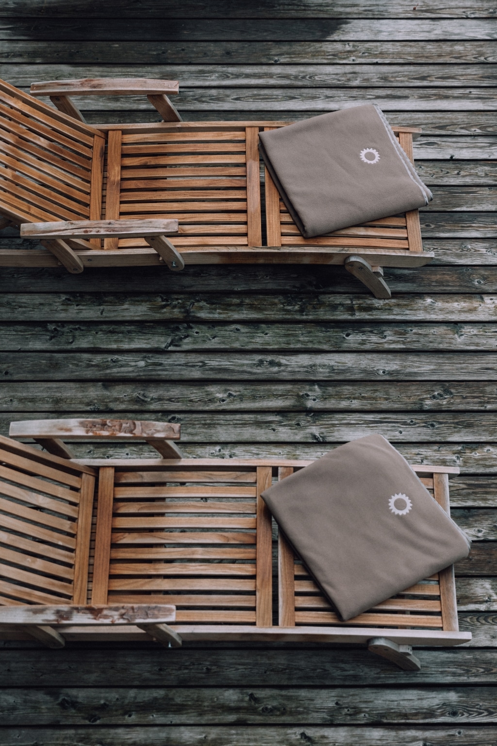 gefaltete Handtücher auf Holzliegen im AlpinSpa