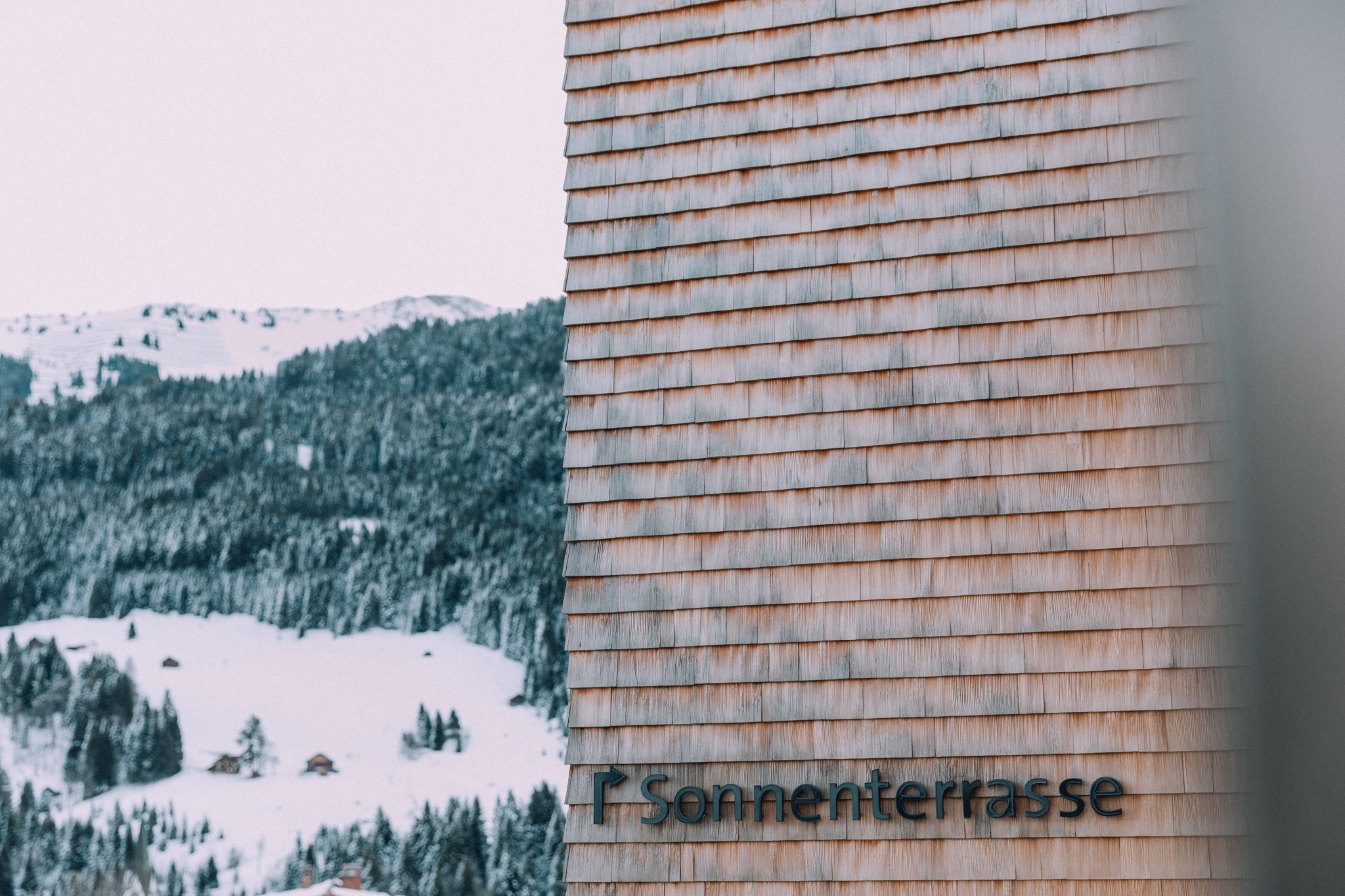 Beschriftung mit Pfeil: Sonnenterasse Fotografiert im Winter an Hausfassade