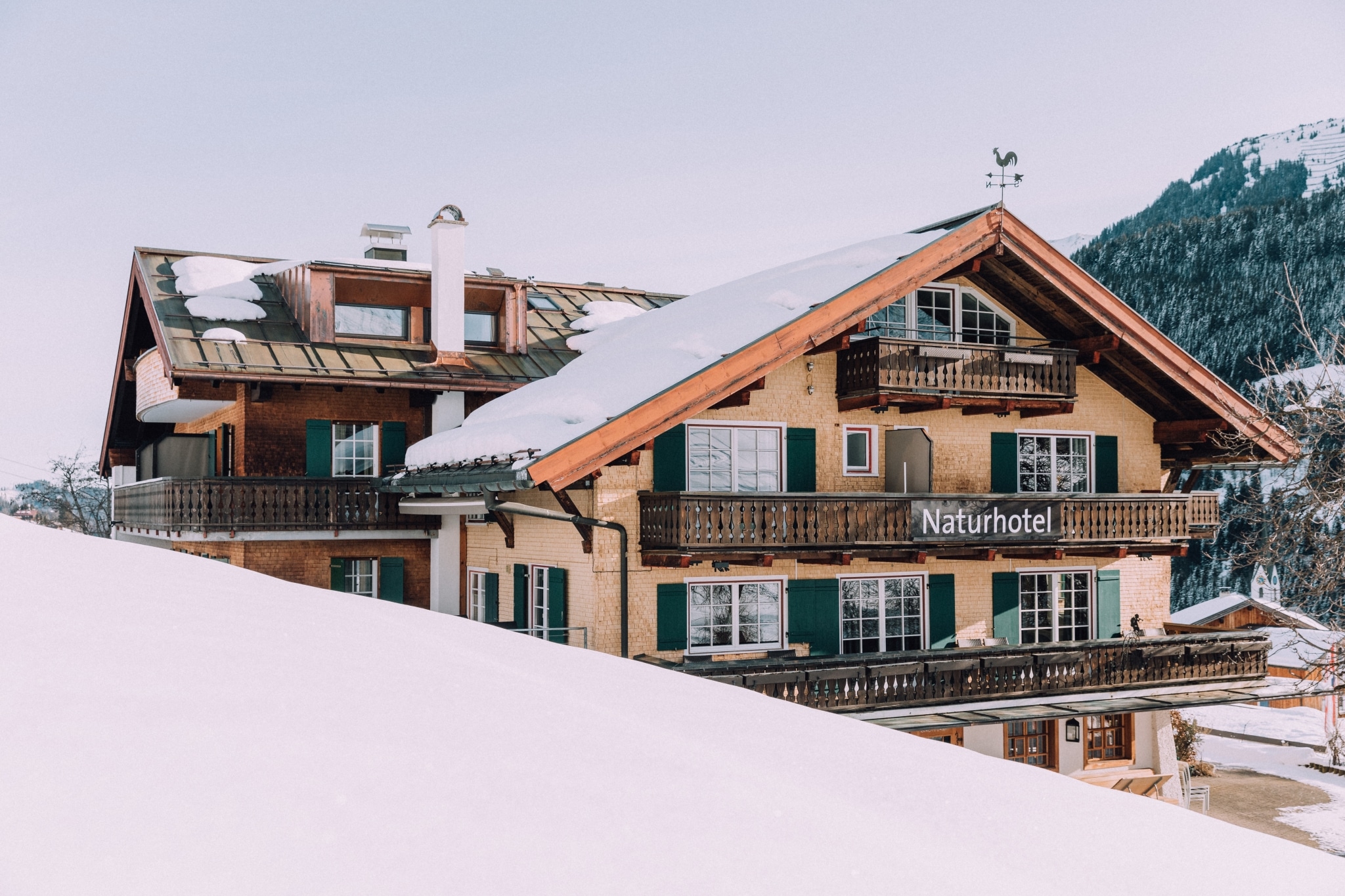 verschneites Naturhotel von Dachterrasse fotografiert