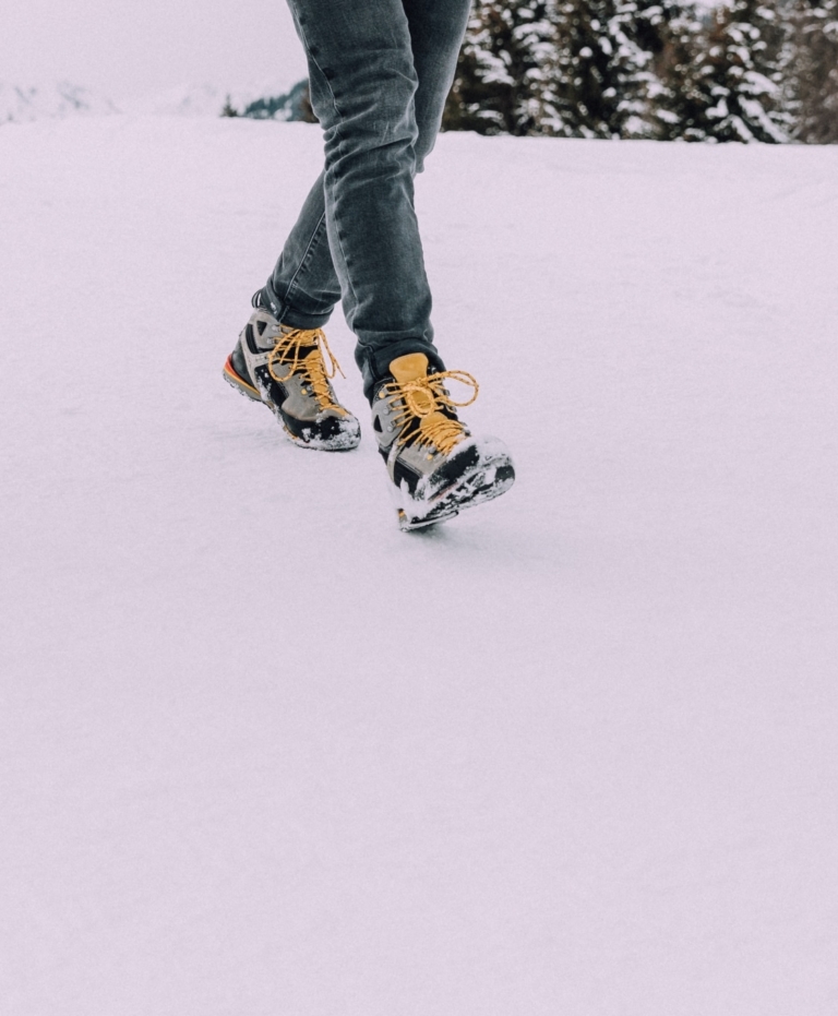 Wanderschuhe mit gelben Schnürsenkel im Schnee