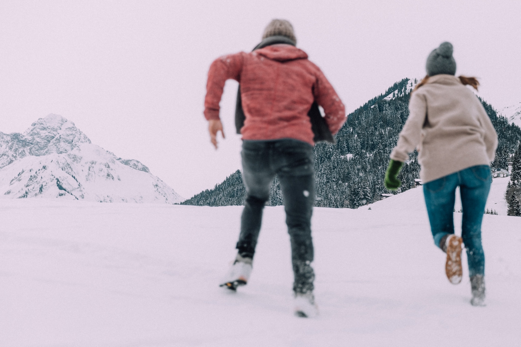 Magdalena und Manu rennen durch den Schnee am Berg