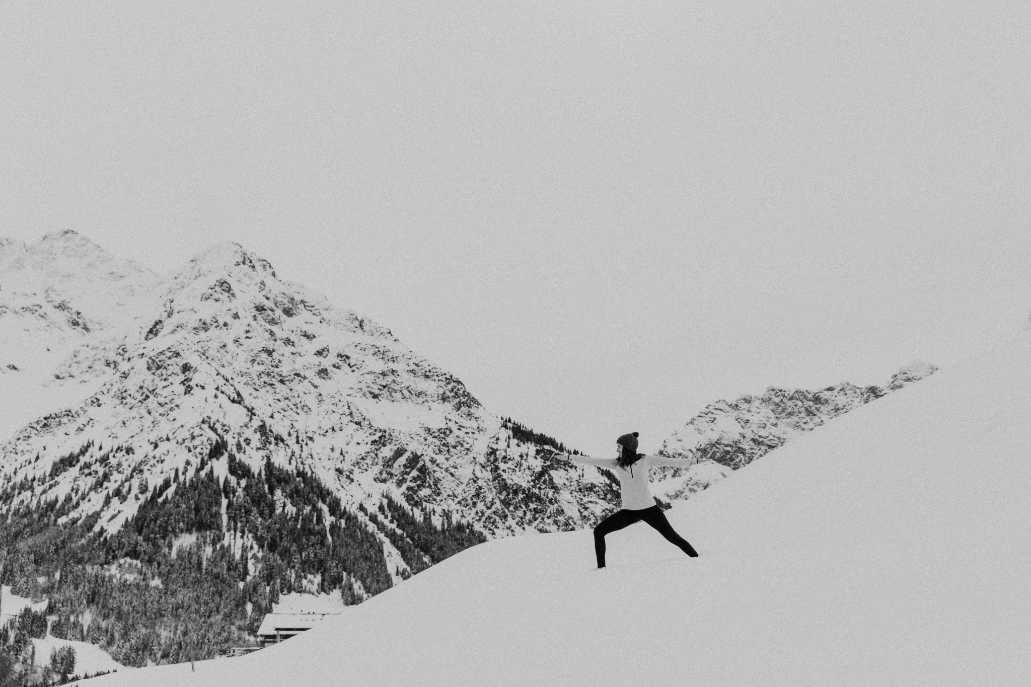 Magdalena beim Yoga in den verschneiten Bergen Weitwinkel sw