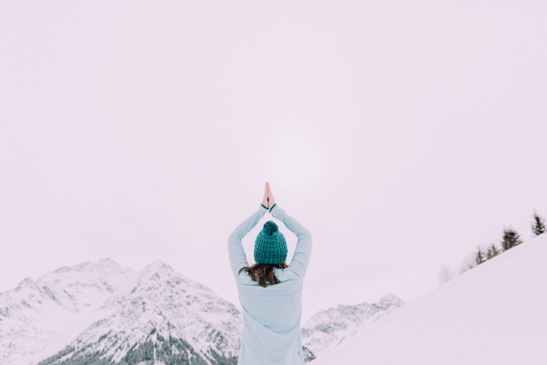 Magdalena beim Yoga im Schnee mit Blick zum Berg hell