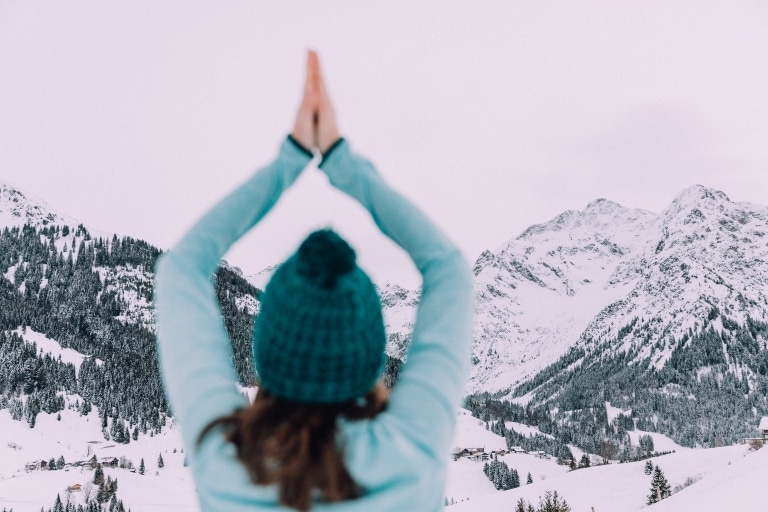 Magdalena beim Yoga im Schnee mit Blick in die Berge