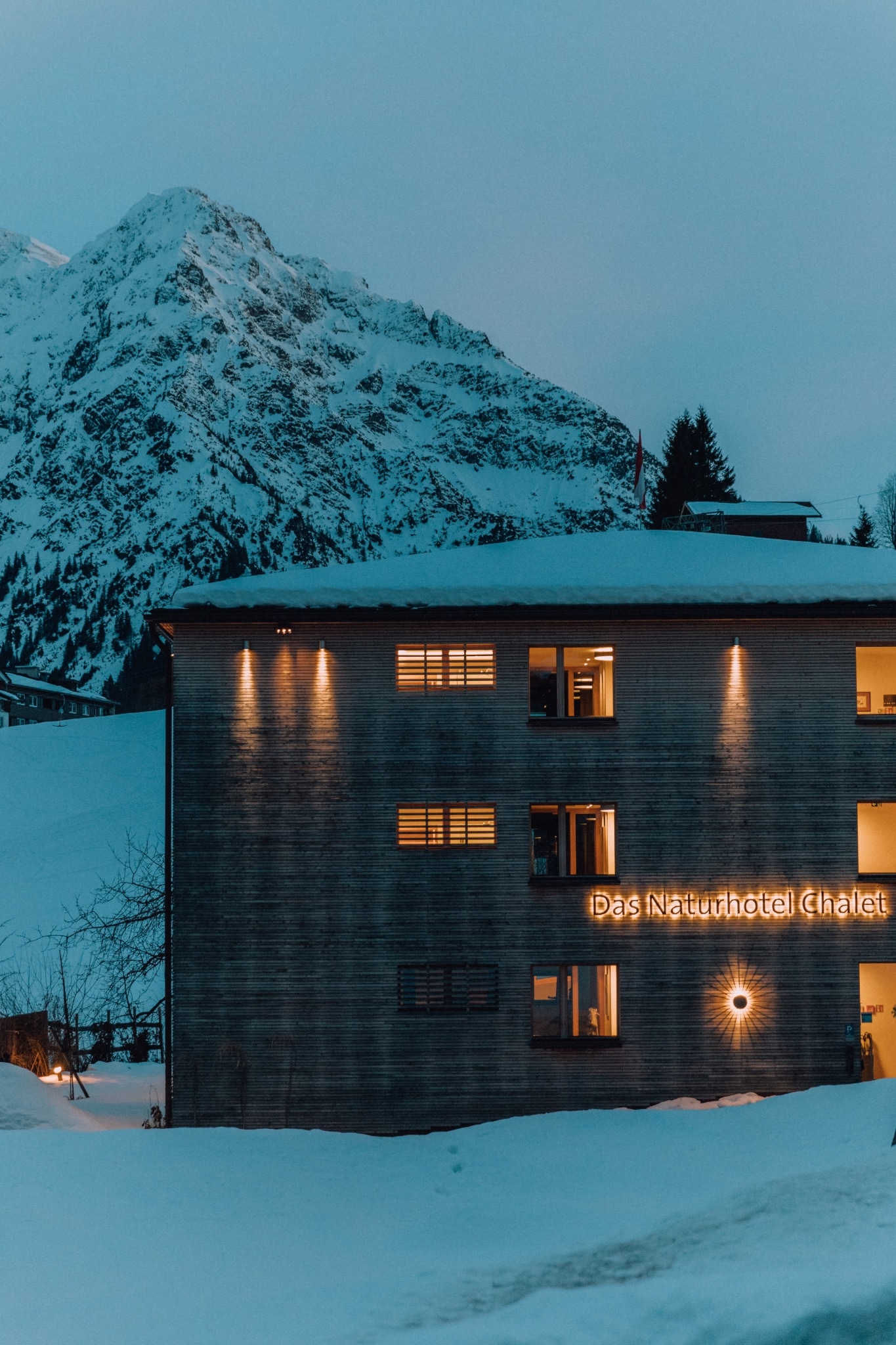 Das Naturhotel Chalet eingebettet in verschneite Winterlandschaft.