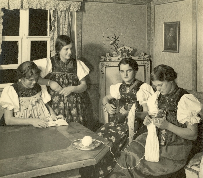 junge Frauen sitzen an Walsertisch und stricken