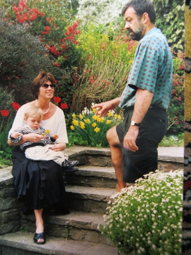 Frau Kessler mit Kind auf dem Arm und Herr Kessler im Garten