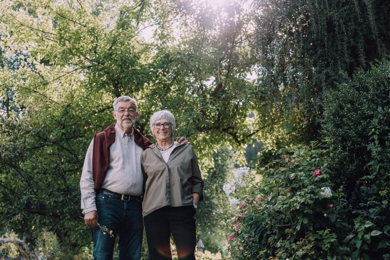 Sieglinde und Klaus Kessler vor grünen Bäumen und Büschen