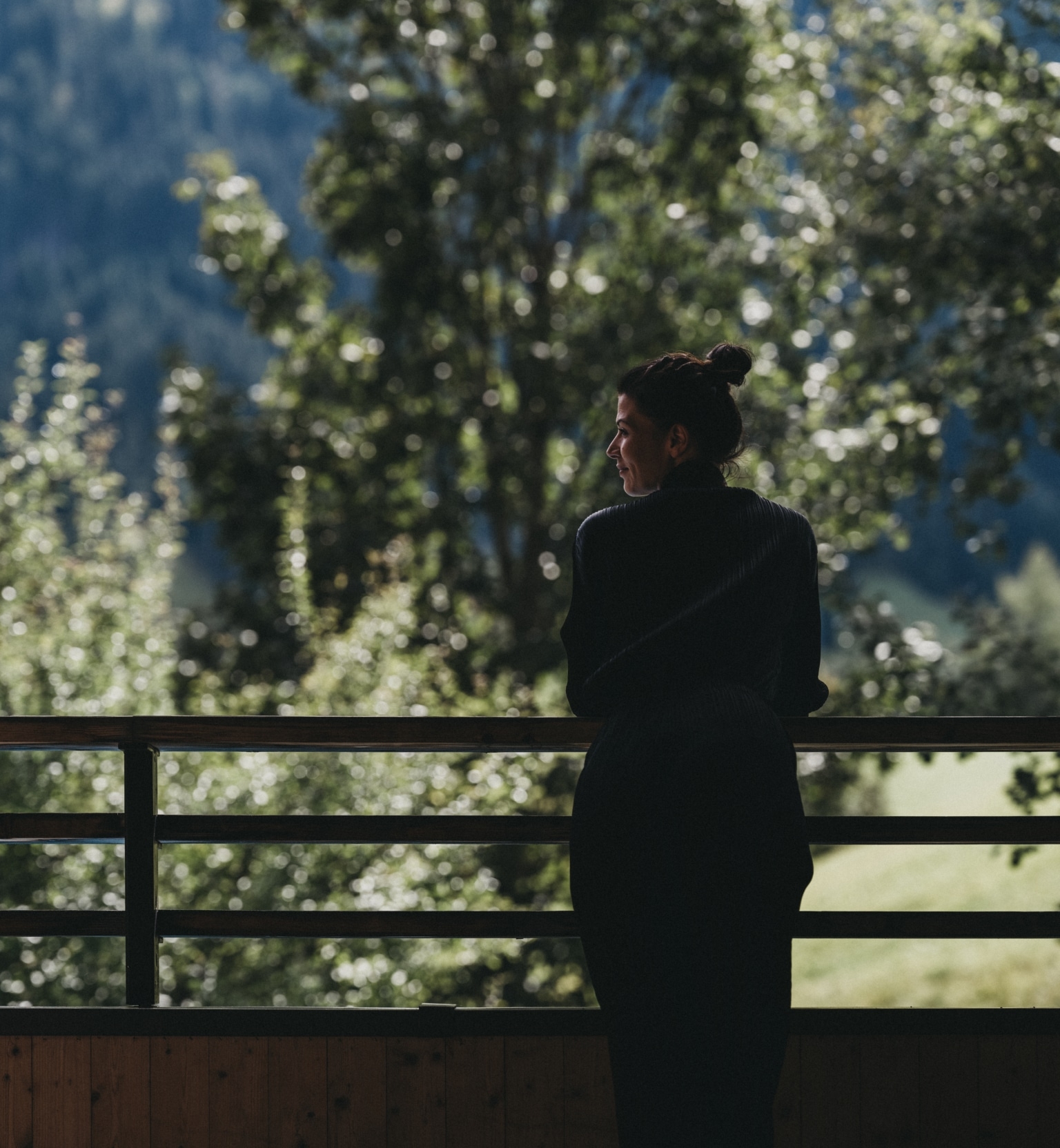 Frau mit schwarzem Kleid auf dem Balkon im Naturhotel.