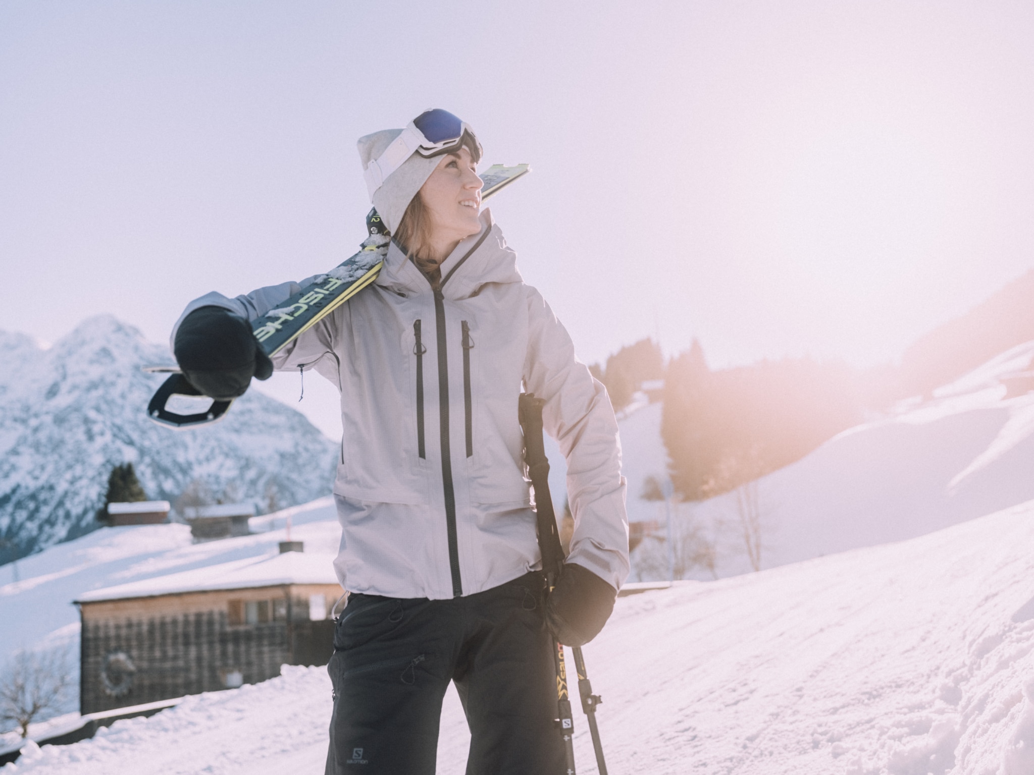 Frau mit Ski auf der Piste hinter dem Naturhotel.
