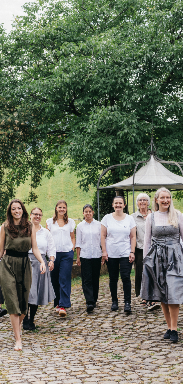 Teambild Frauen laufen lachend durch den Garten
